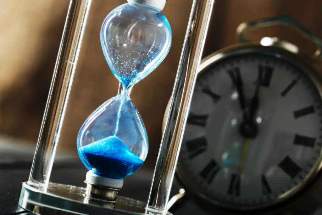 A hour glass and clock measuring the span of time.